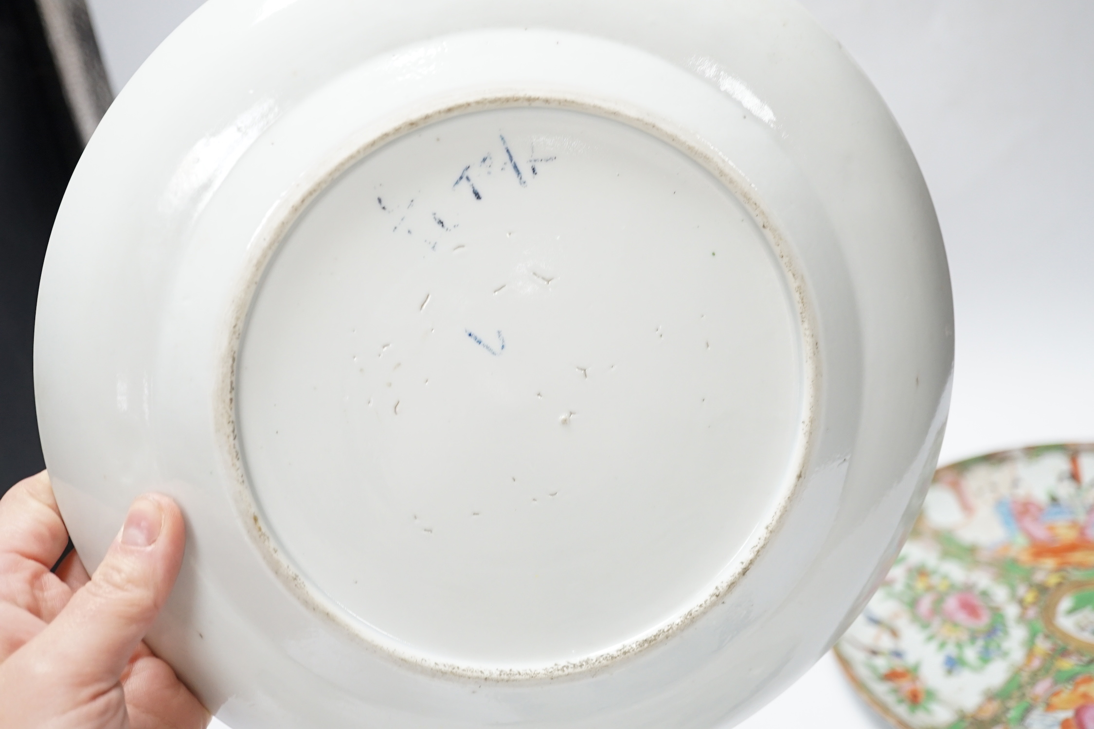 Two 19th century Chinese famille rose plates and an 18th century blue and white plate, 24cm in diameter